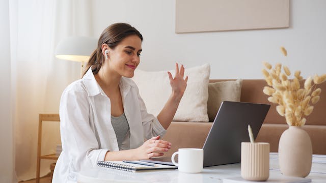 A woman sitting in front of a laptop, working on large video files